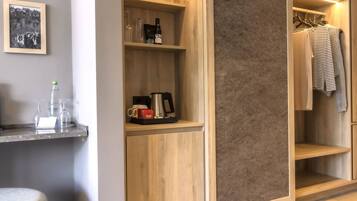 A modern bathroom with a wooden vanity, a towel rack, and a shelf with toiletries.