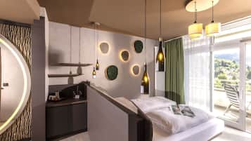 A modern bedroom with a bed, a built-in desk, and a large window with a view.