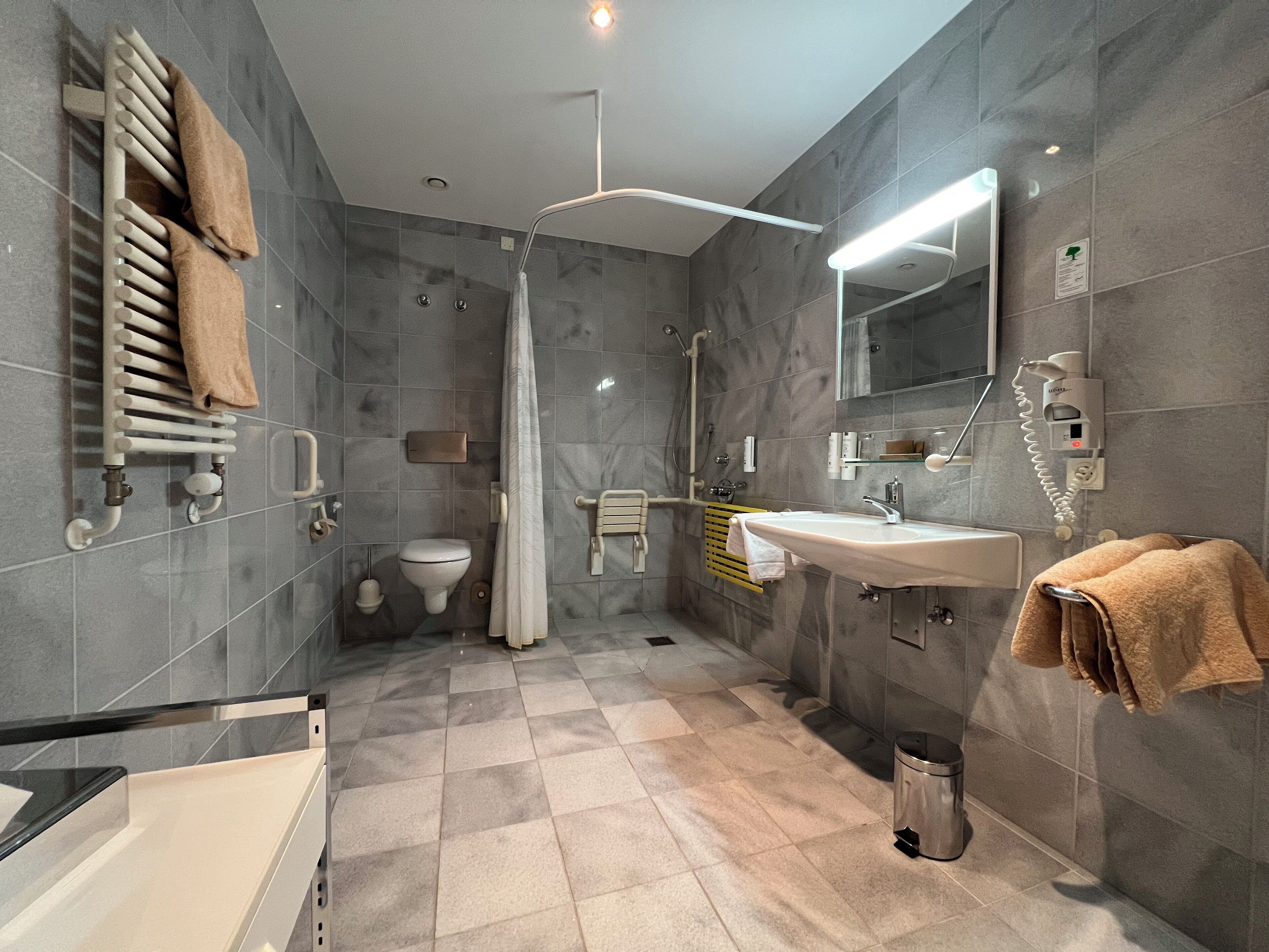 Ein modernes Badezimmer mit Badewanne, Dusche, Toilette und Waschbecken.