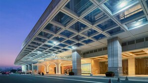 A modern hotel with a glass facade, large columns, and a well-lit entrance. - Oriental Riverside Hotel Shanghai (Shanghai)