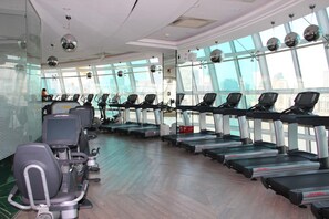 Una palestra con tapis roulant ed ellittiche, ampie finestre e un design interno moderno.