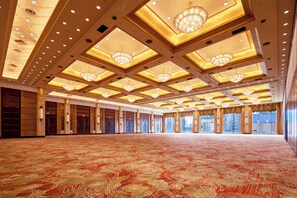Un salón espacioso con un suelo de motivi, grandes candelabros y un techo alto con tragaluces.