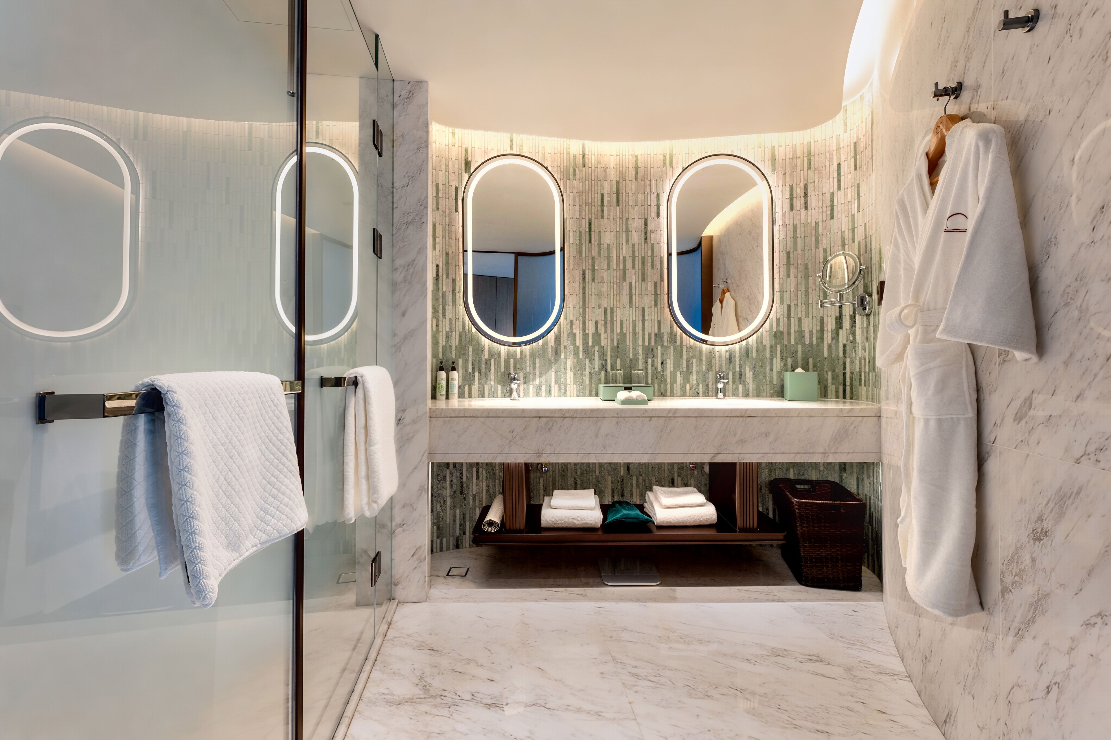 A modern bathroom with a glass shower enclosure, a vanity with a marble countertop, and a large mirror.