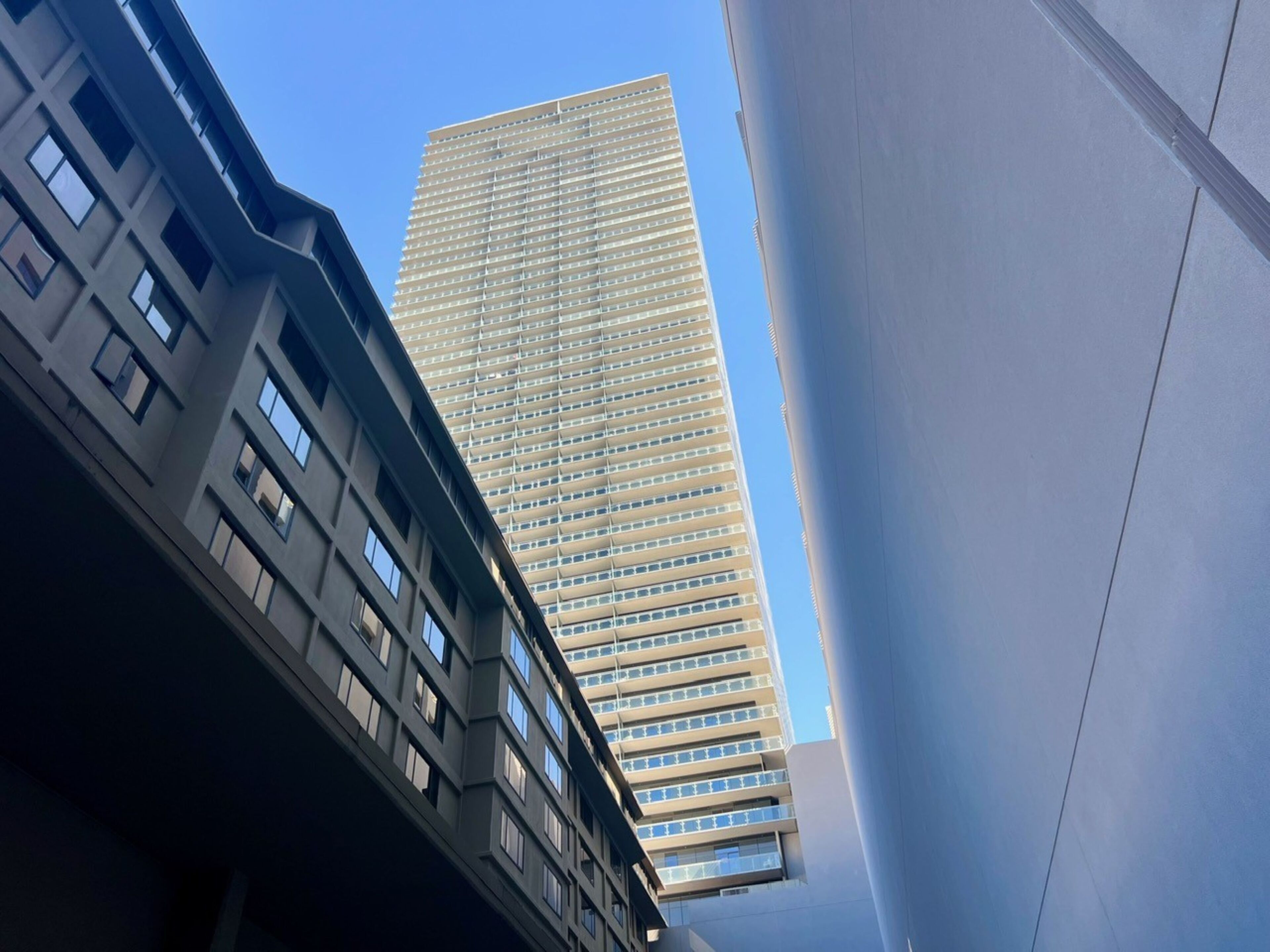 A tall, modern building with a grid of windows and a flat roof.