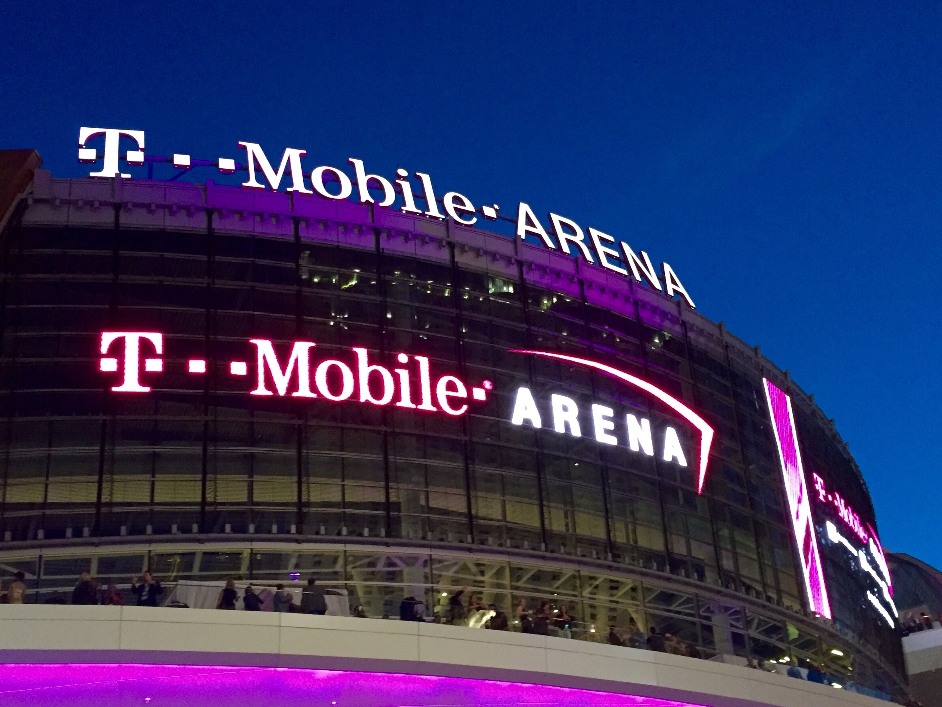 Arena T-Mobile com um grande letreiro iluminado e fachada de vidro.