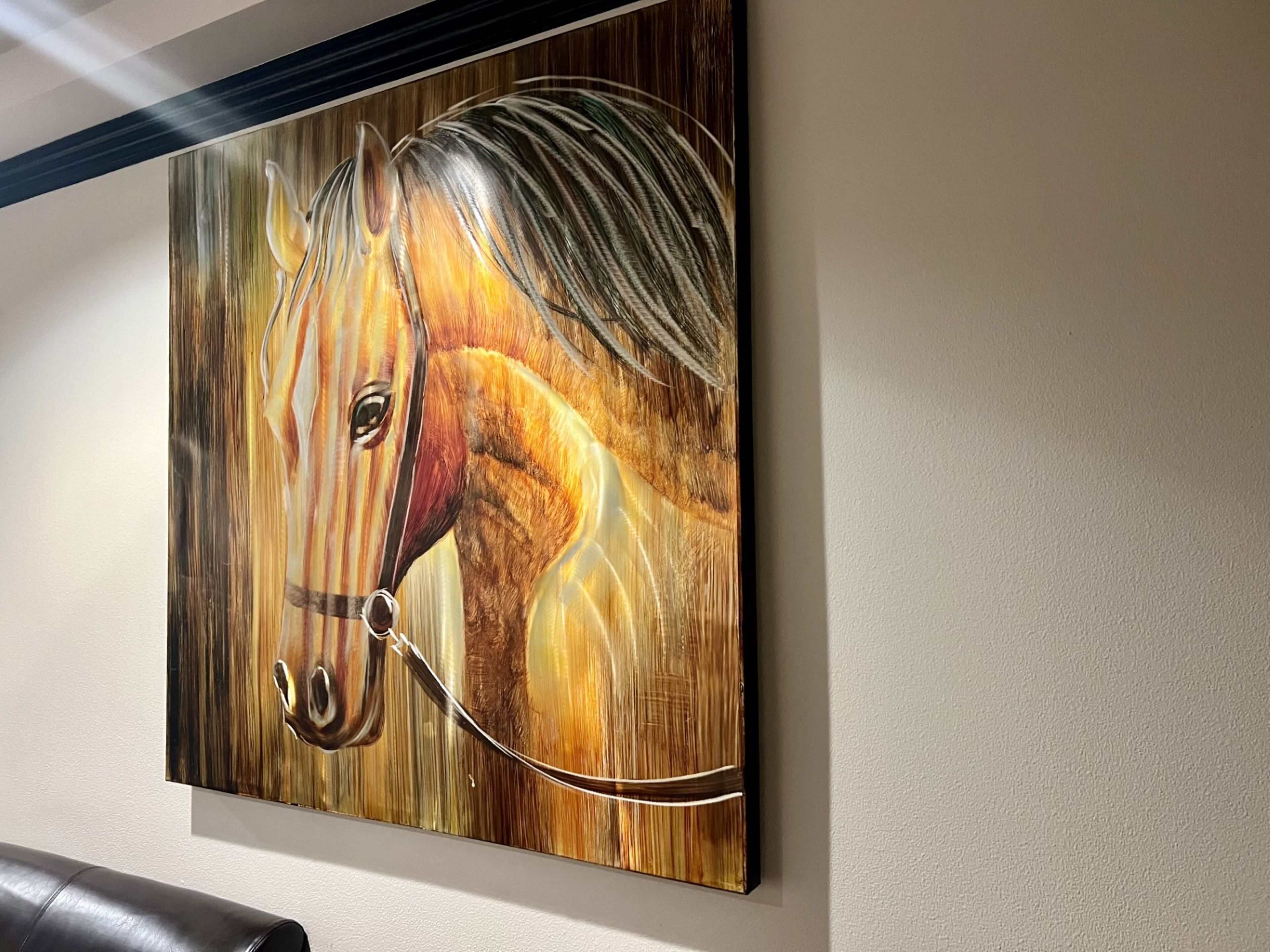 A wall-mounted painting of a horse.