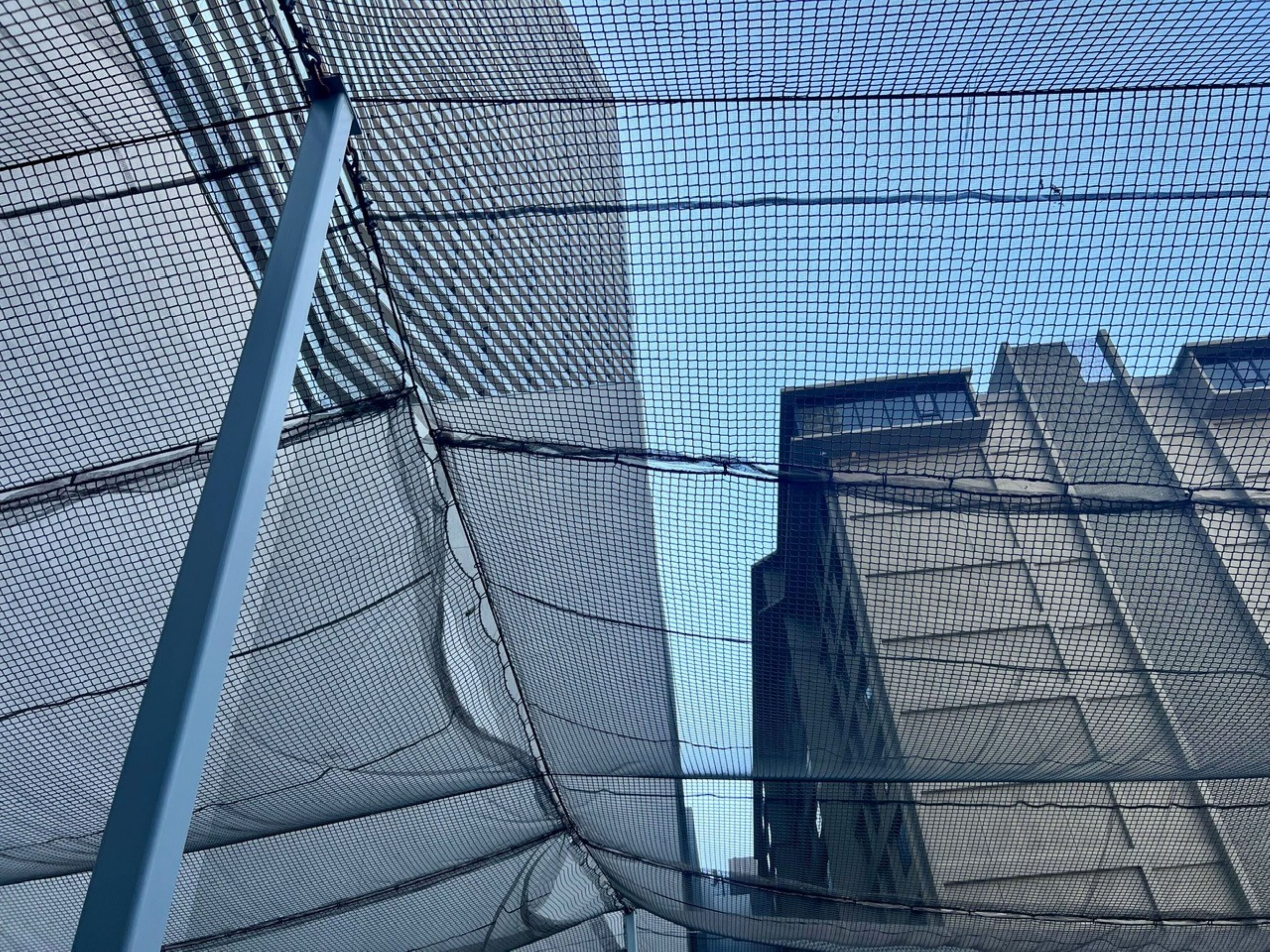 Primer plano de una estructura de malla, probablemente parte del exterior de un edificio.