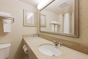 A bathroom with a sink, mirror, towel rack, and toilet.