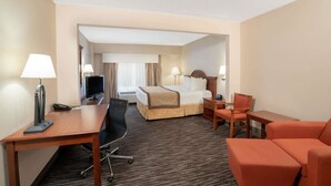 A hotel room with a bed, desk, chair, and a small table. - Wingate by Wyndham Charlotte Airport I-85/I-485 (Charlotte)