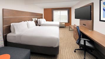 A hotel room with two beds, a desk, a chair, a flat-screen TV, and a window with a view of the outside.
