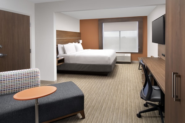 A hotel room with a bed, a desk, a TV, a sofa, and a small table. - Holiday Inn Express & Suites Baltimore - BWI Airport North by IHG (Linthicum Heights)