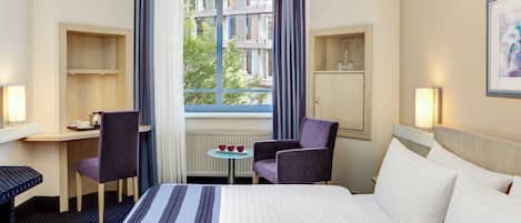 Ropa de cama hipoalergénica y caja de seguridad en la habitación