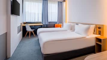 Ropa de cama hipoalergénica y caja de seguridad en la habitación