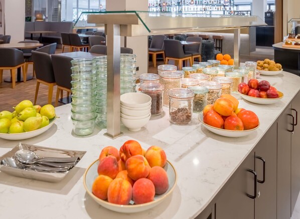 A buffet area with various fruits and food items.