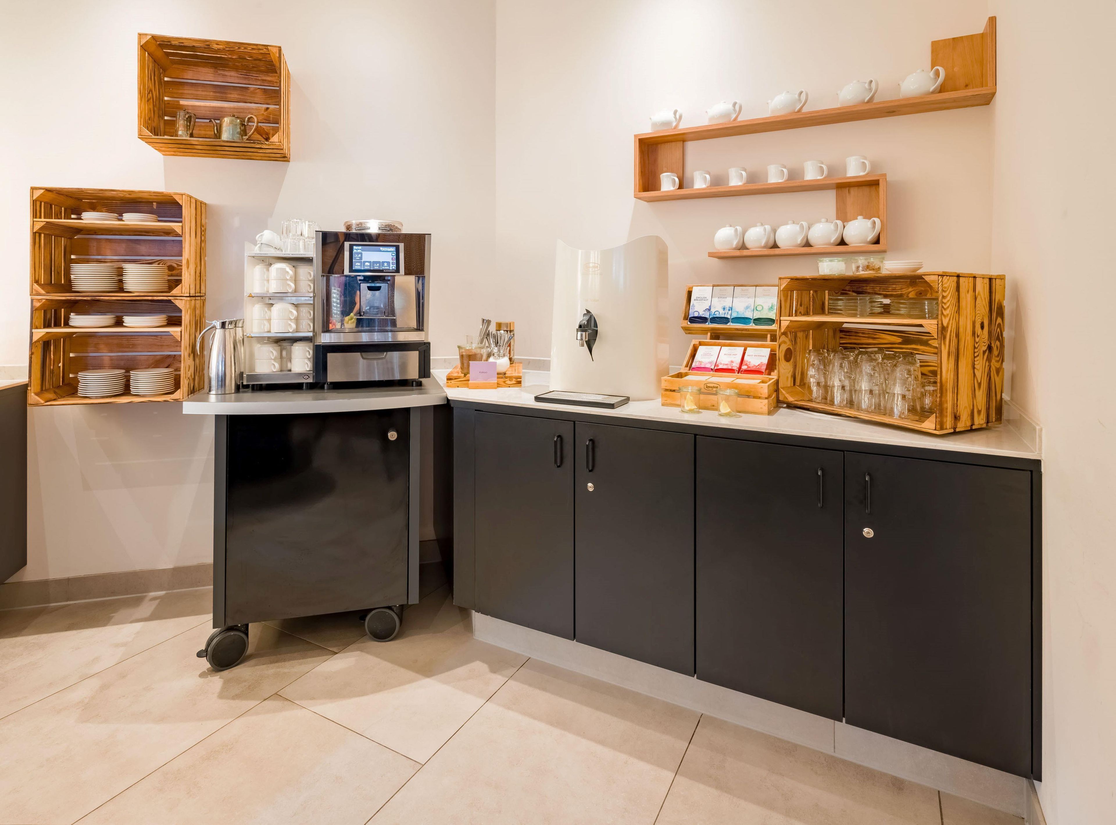 Eine moderne Küche mit Kaffeemaschine, Teeausstattung und Stauraumschränken.