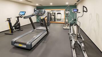 Ein Fitnessstudio mit Laufbändern, Crosstrainern und Gewichtmaschinen.