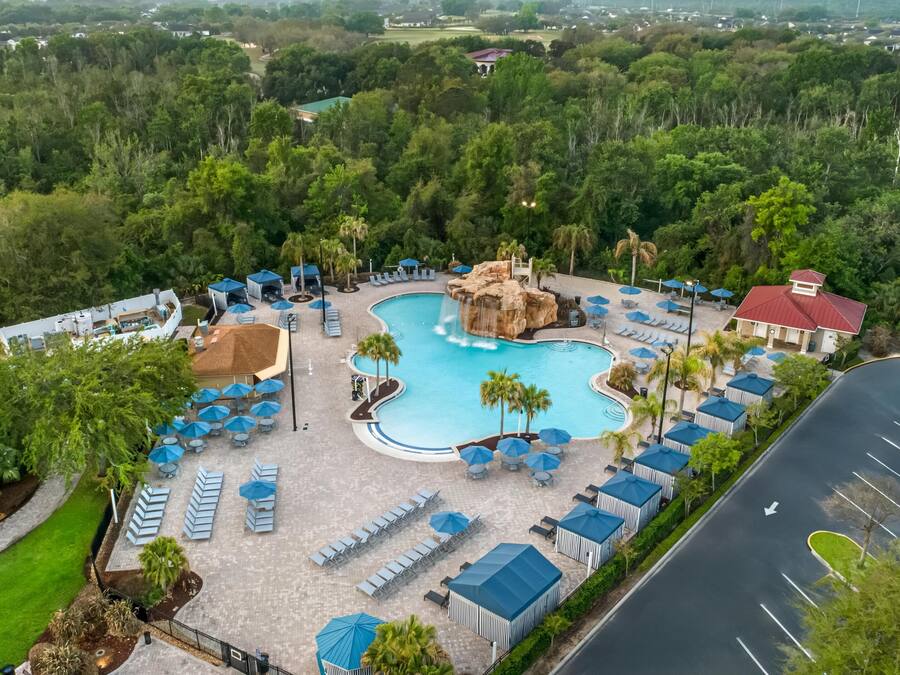 A resort with a large pool, lounge chairs, and a waterfall feature.