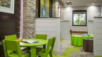 Enjoy a peaceful stay in this serene room featuring a large window, a green table, and a comfortable seating area.