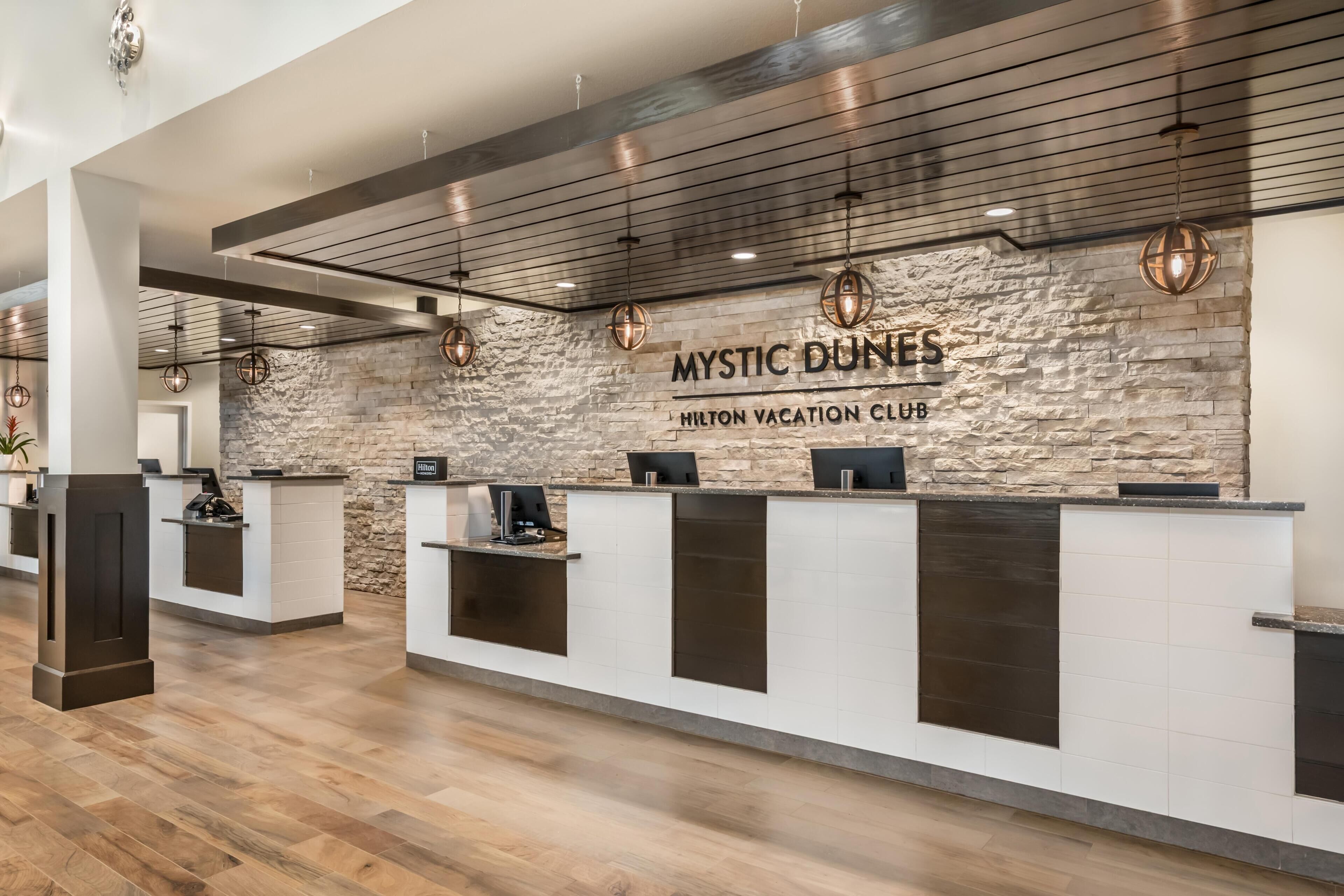 A reception area with a stone wall, wooden ceiling, and modern furnishings.