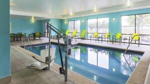A swimming pool with a lifeguard stand, yellow lounge chairs, and a view of the outside. - SpringHill Suites by Marriott Austin Parmer/Tech Ridge (Austin)