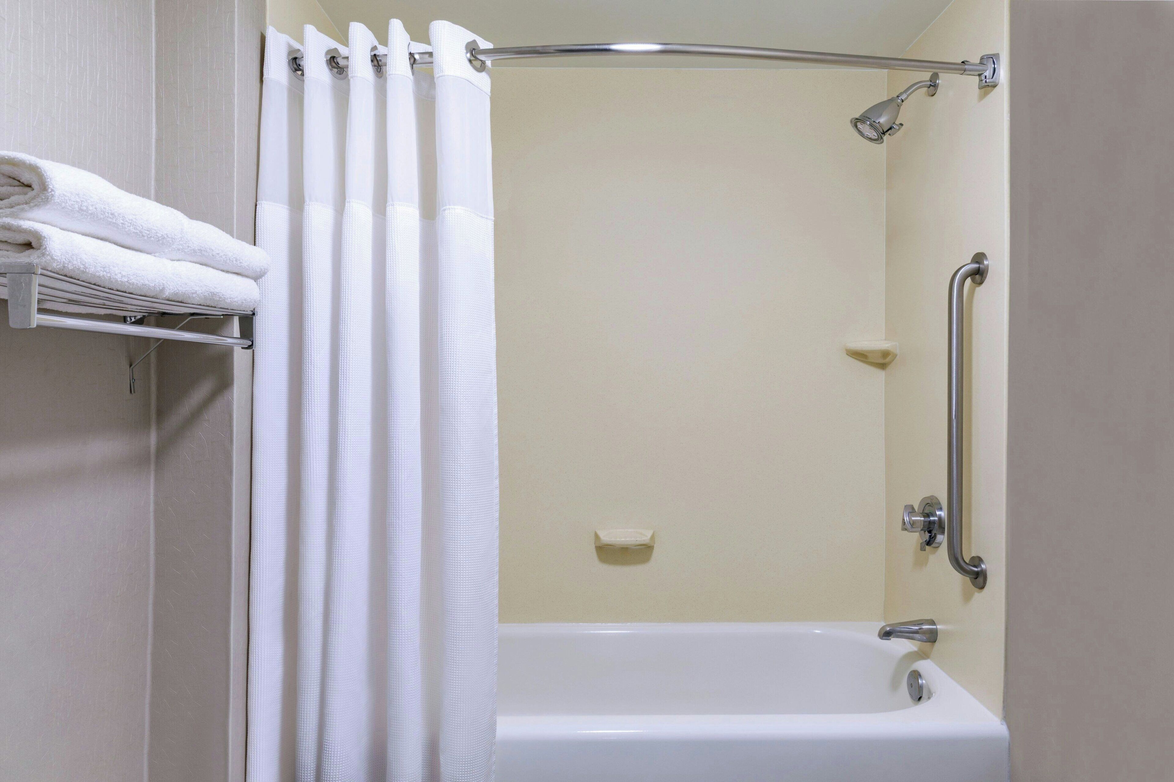 Un baño con ducha, bañera y un perchero.