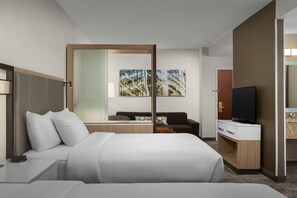 A modern hotel room with a large bed, a desk, a television, and a seating area with a sofa and a coffee table. - SpringHill Suites by Marriott Boston Peabody (Peabody)