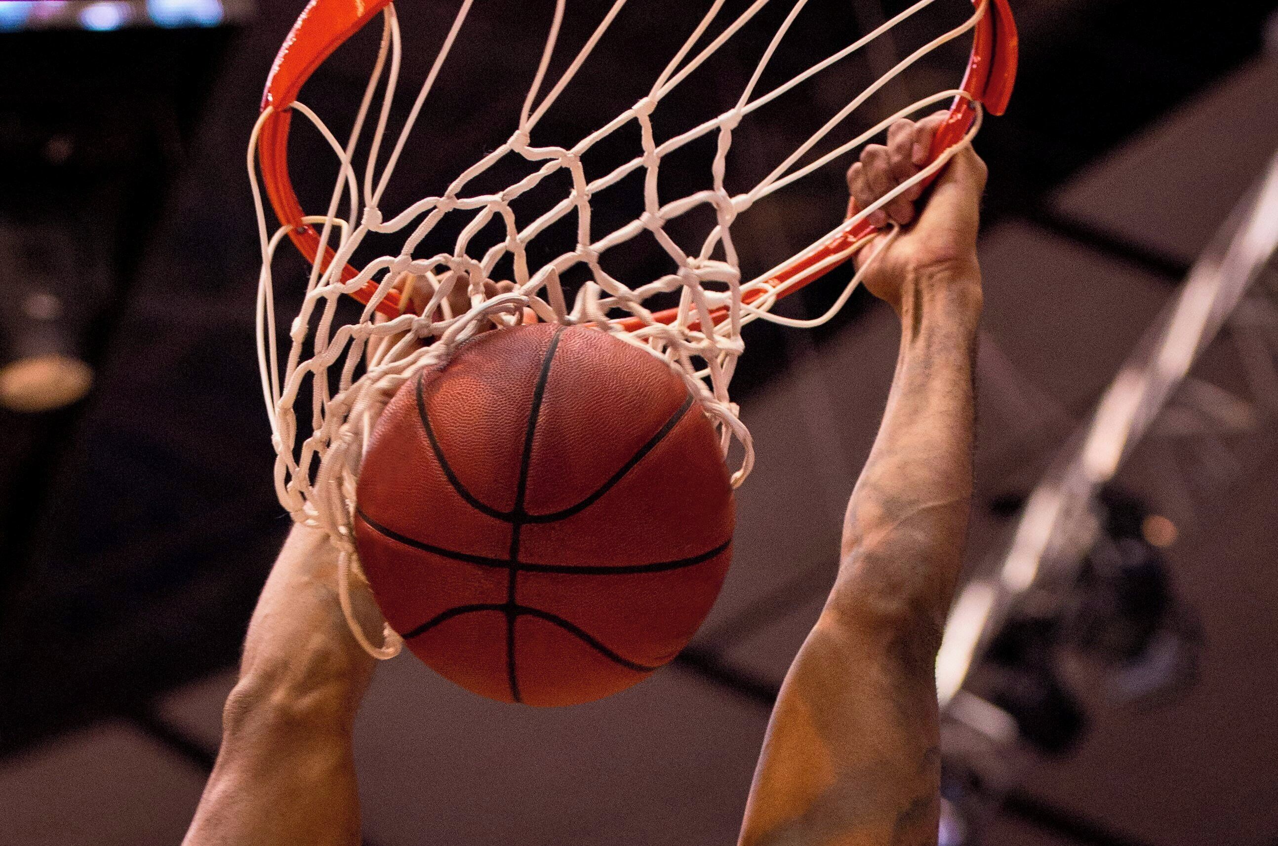 Un aro de baloncesto con red y un balón.