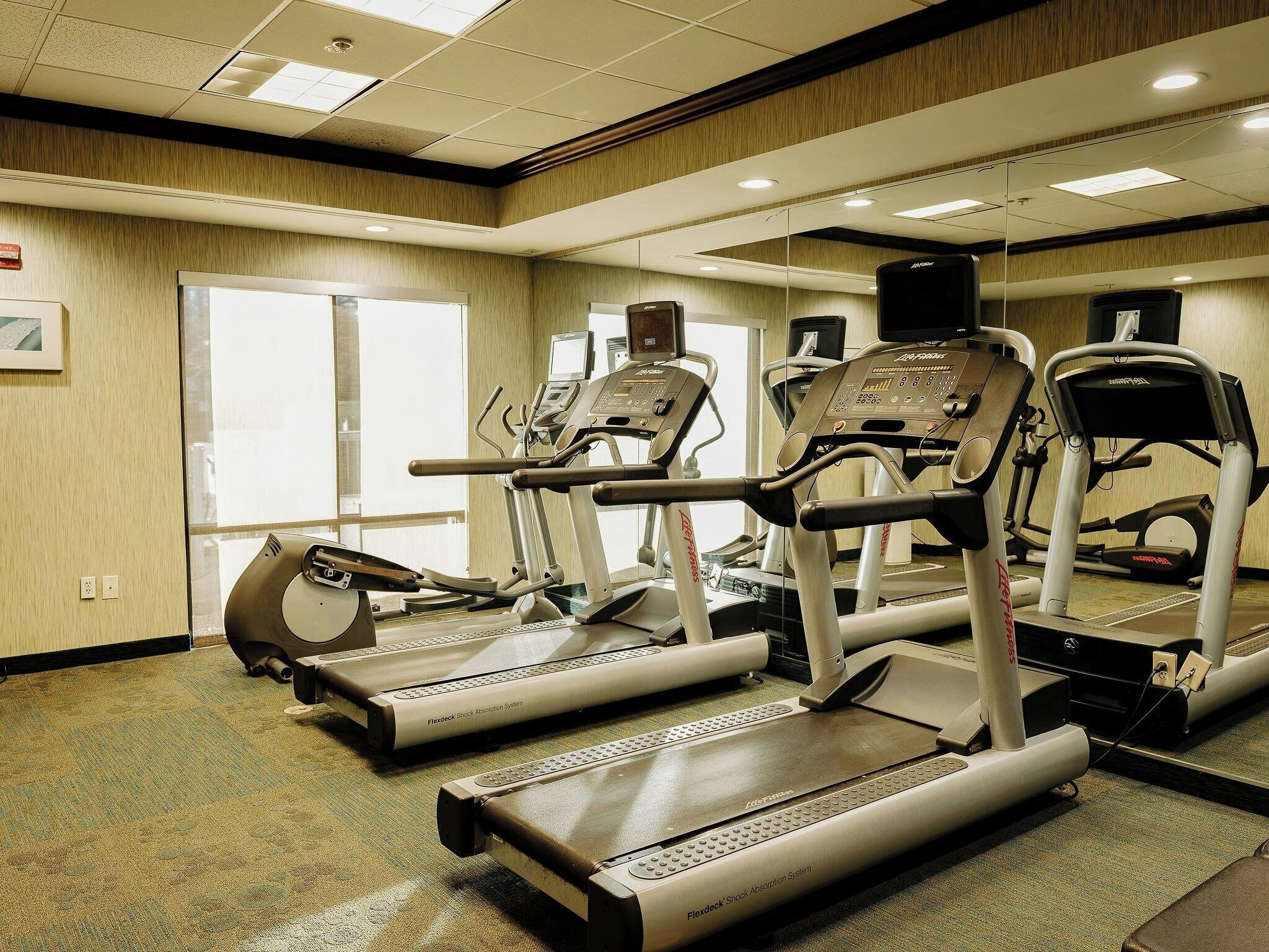 A fitness center with treadmills, ellipticals, and a stationary bike.