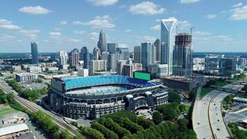 A stadium with a large blue roof, surrounded by modern high-rise buildings and a highway.