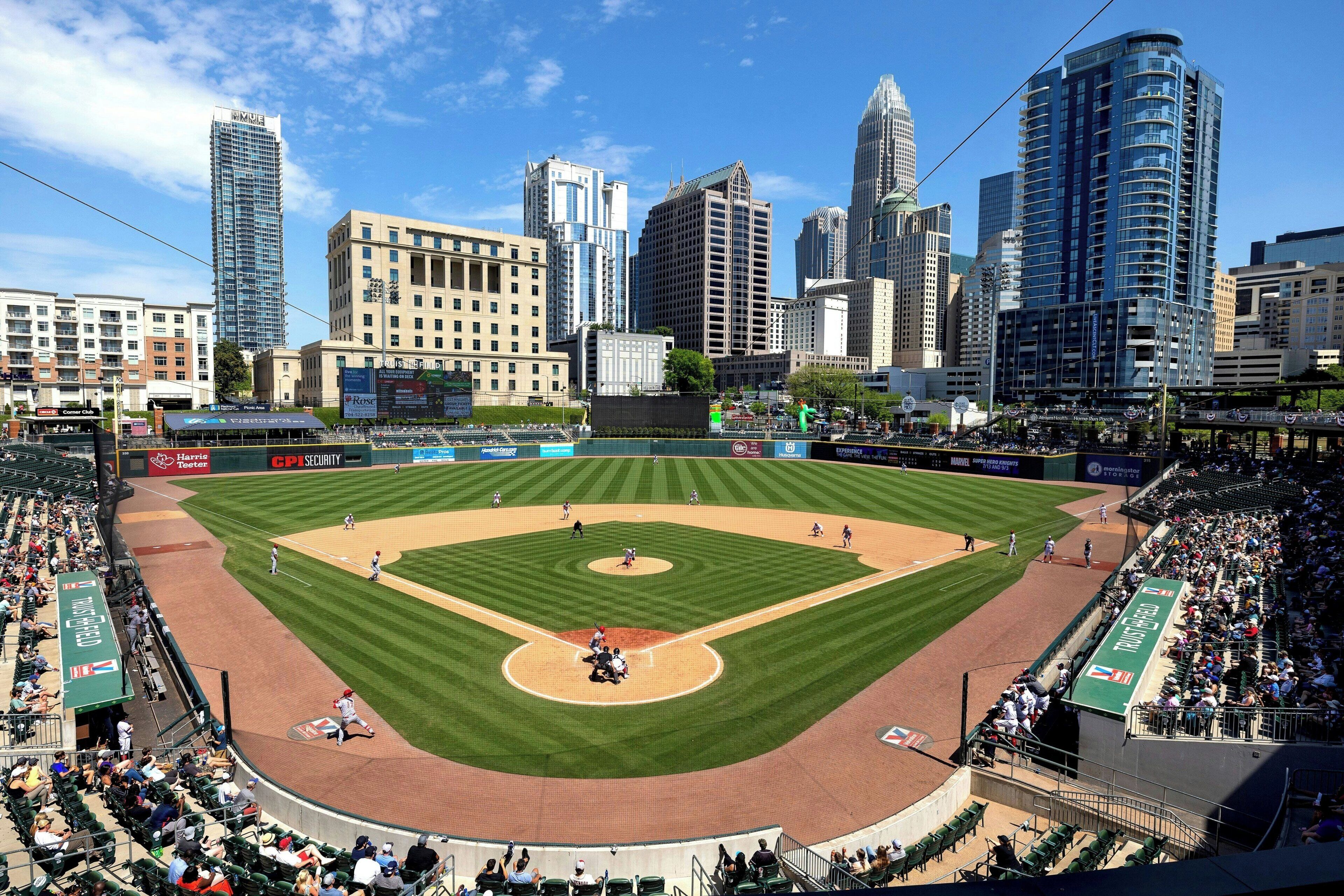 A baseball stadium with a cityscape in the background.
