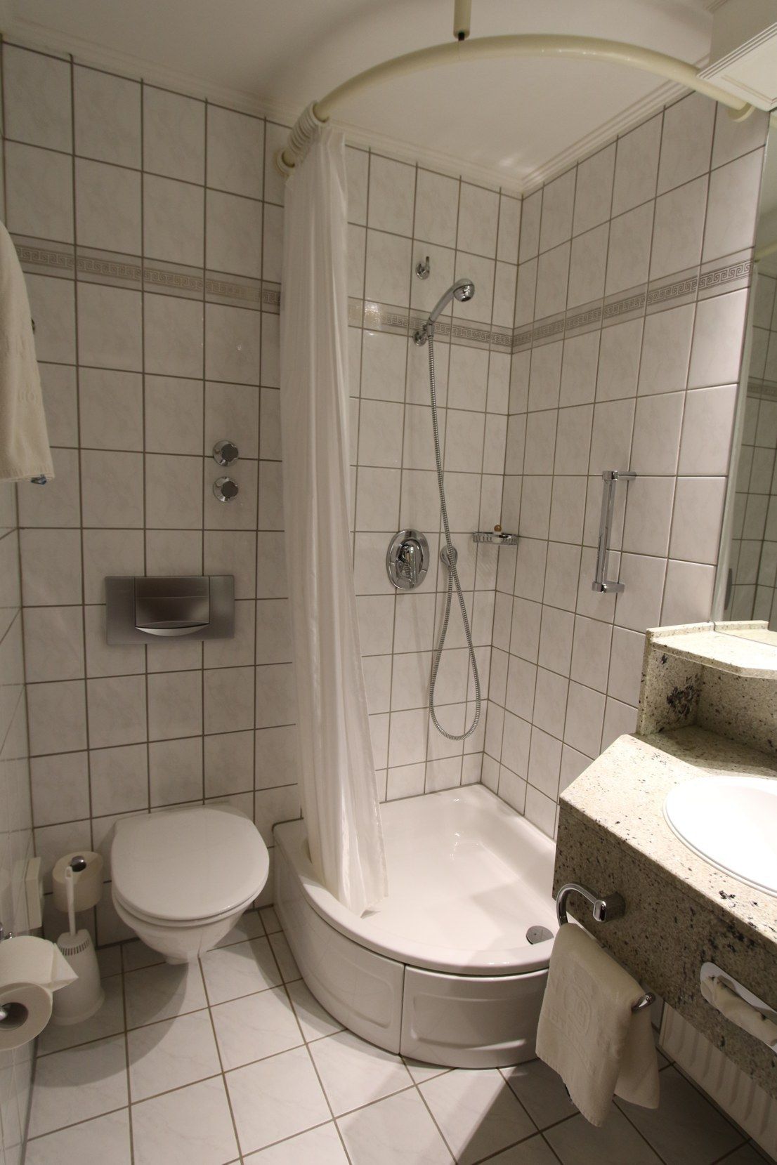 Un baño con ducha, inodoro y lavabo.