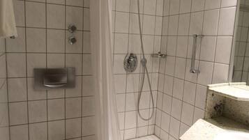 Un baño con ducha, inodoro y lavabo.