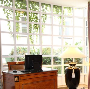 A room with a desk, a computer, and a lamp.