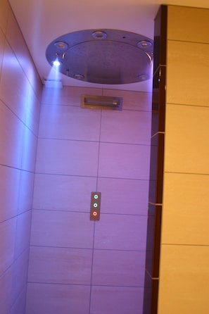 An elevator interior with a control panel and a circular ceiling light fixture.