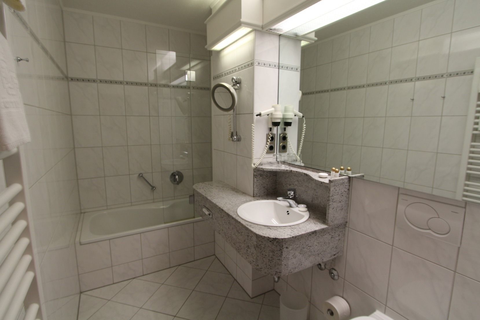 A bathroom with a shower, a sink, and a toilet.