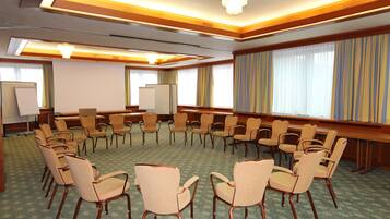 Una sala de conferencias con sillas dispuestas en círculo, una pizarra y una pantalla de proyector.