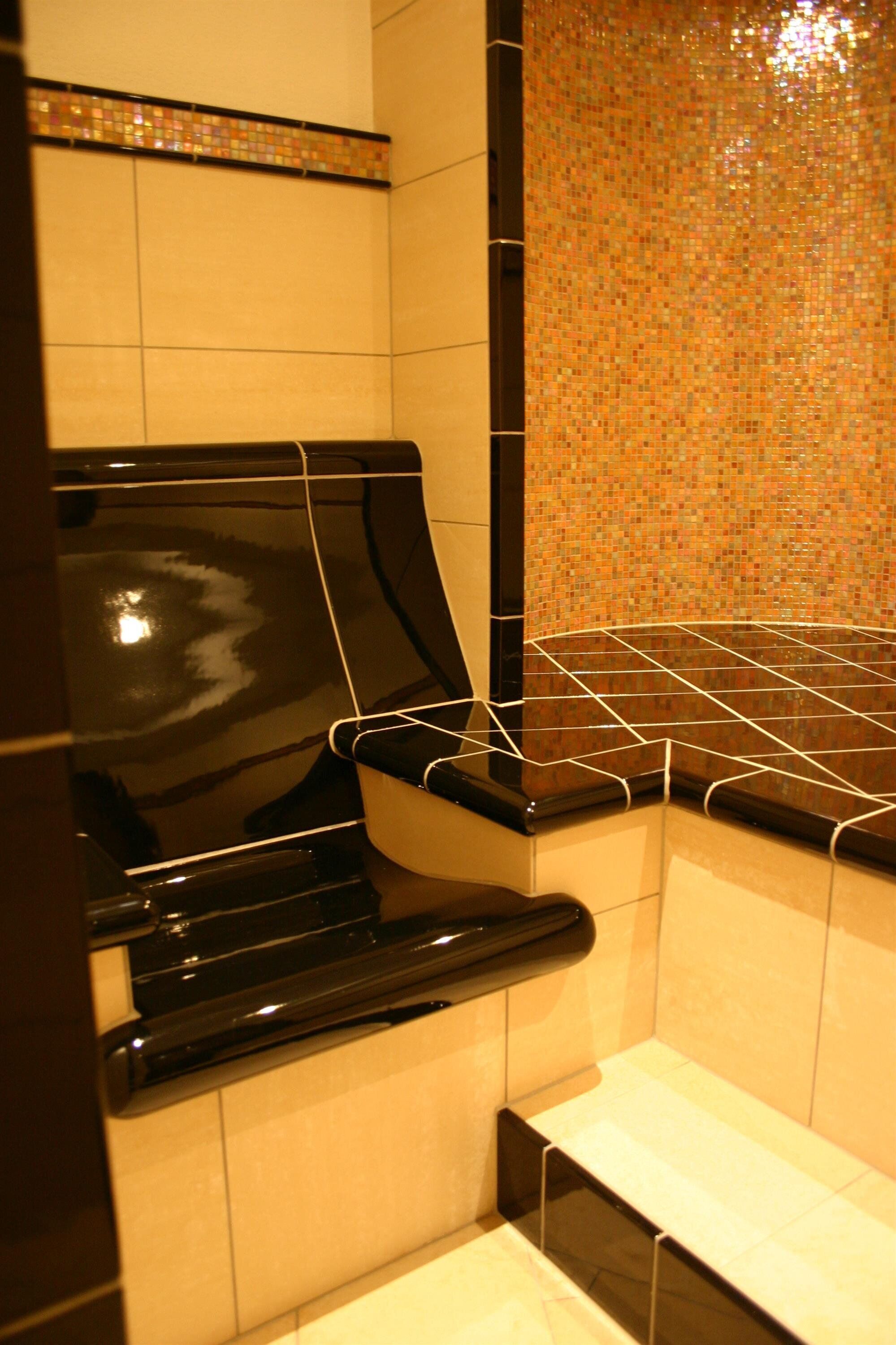 A kitchen with a black countertop, white cabinets, and a tiled backsplash.