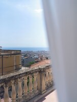 Un balcone con vista sulla città e sul mare.