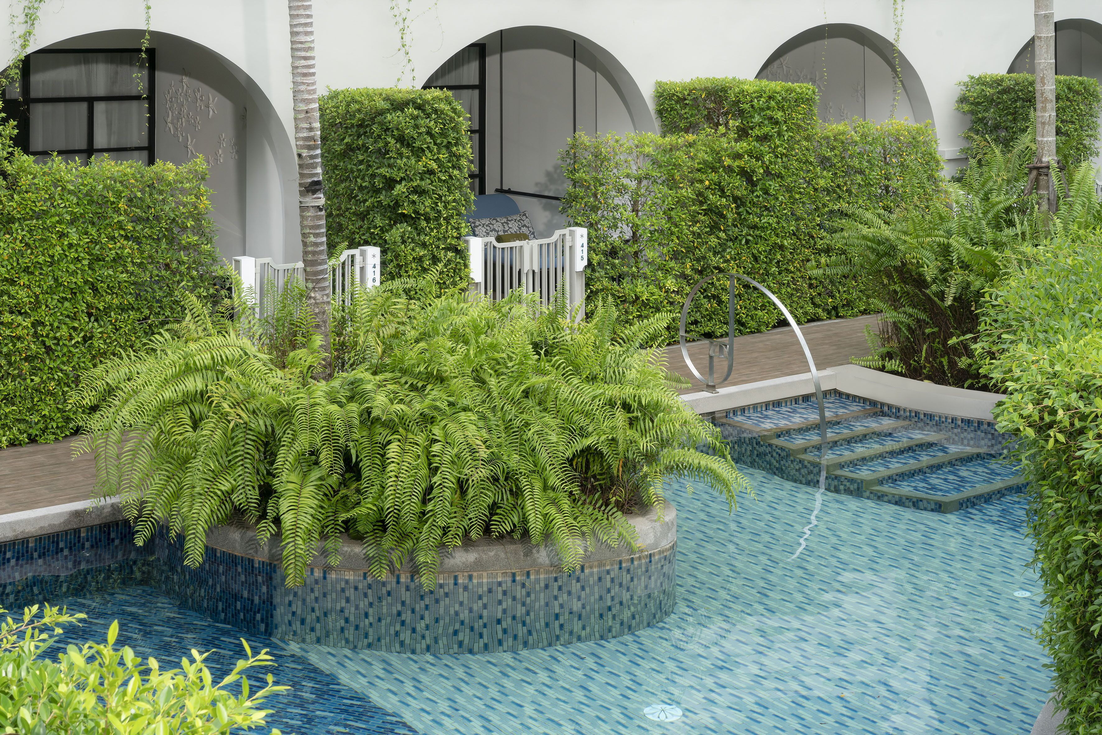 Un espace piscine agrémenté d’un bassin circulaire, entouré d’une végétation luxuriante et doté d’une architecture moderne.