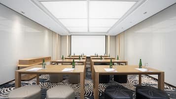 A conference room with a large table, chairs, and a carpeted floor.
