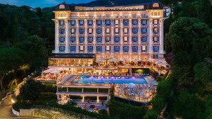 Un hotel grande con varios pisos, piscina y zonas de estar al aire libre.