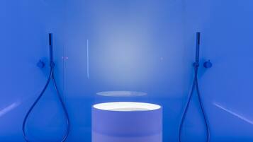 Ein Badezimmer mit einem zentralen Waschbecken, zwei Duschköpfen und einer blauen Wand.
