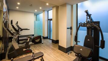 A gym with cardio machines, weight benches, and a squat rack.