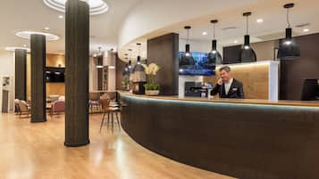 A modern reception area with a curved counter, large pillars, and pendant lighting.
