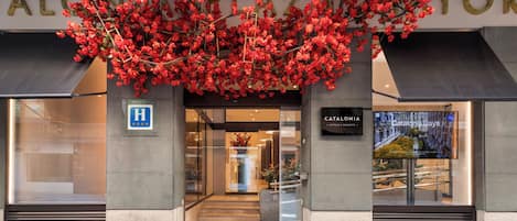 La entrada del Catalonia Hotels & Resorts Plaza, con un gran letrero sobre la entrada y un distintivo de accesibilidad para personas con discapacidad visible.