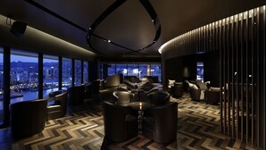 A modern lounge with a panoramic city view, comfortable seating, and a stylish ceiling design. - Kobe MerikenPark Oriental Hotel (Kobe)