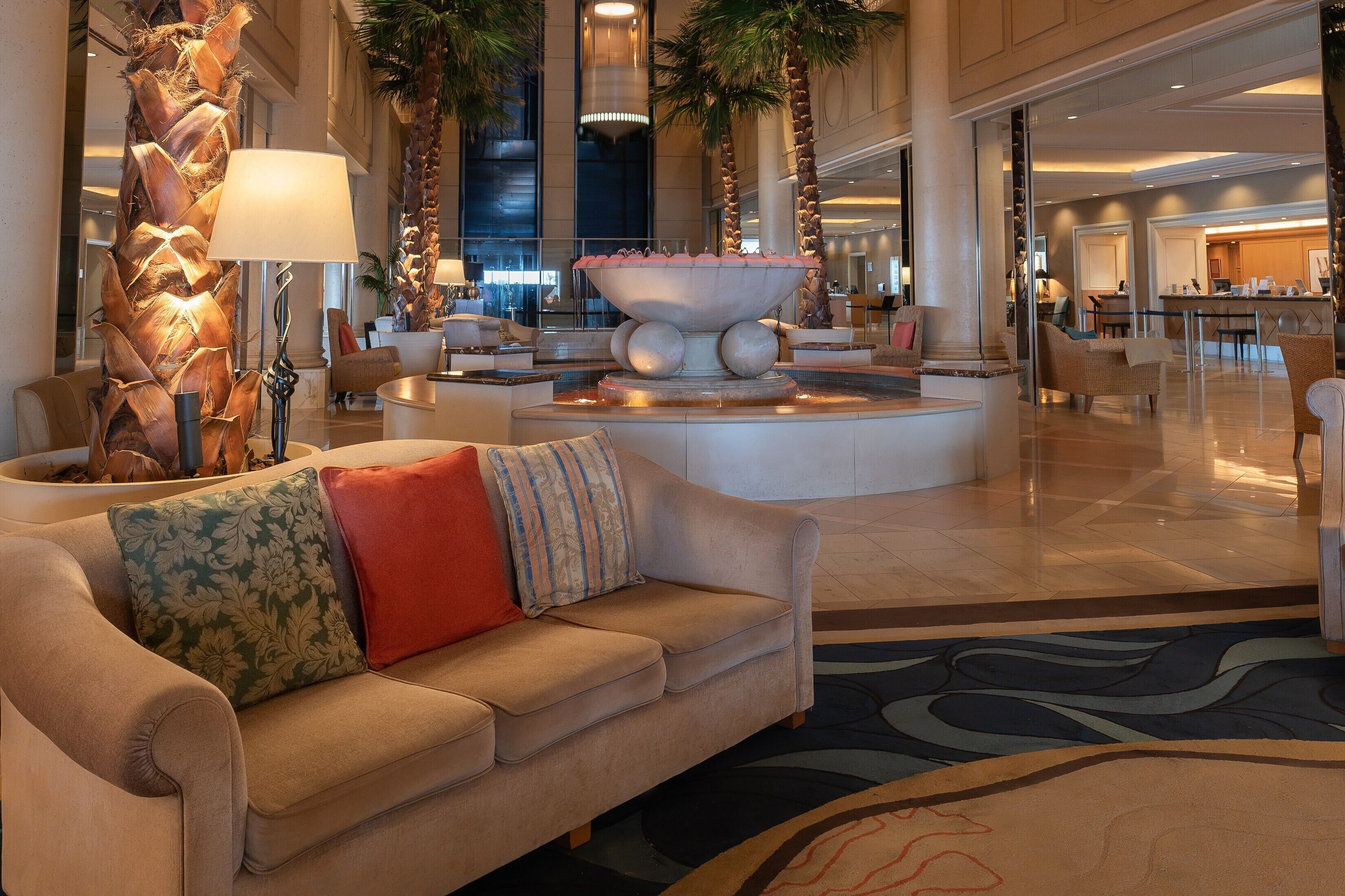 En rummelig lobby med en central springvand, behagelige siddepladser og et moderne interiørdesign.