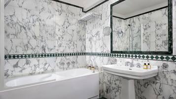 Une salle de bain avec une baignoire, un lavabo et un miroir.