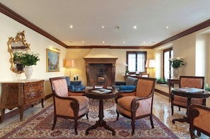 A traditional room with a fireplace, patterned carpet, and classic furniture. - Sina Palazzo Sant'Angelo (Venice)