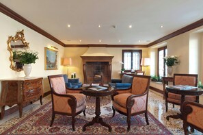 A traditional room with a fireplace, patterned carpet, and classic furniture. - Sina Palazzo Sant'Angelo (Venice)
